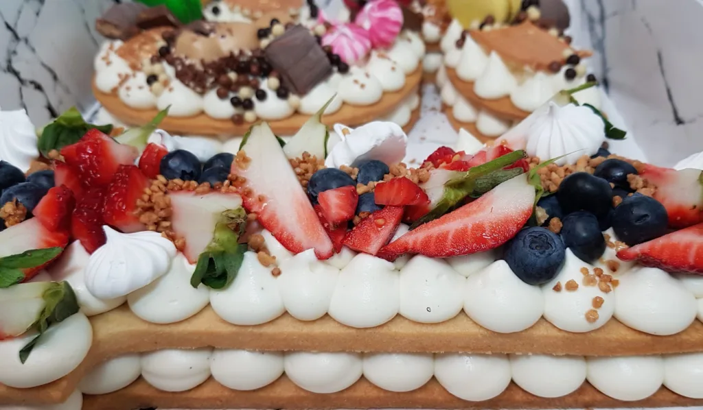 צילום תקריב של עוגת מספרים עם פירות תות ואוכמניות